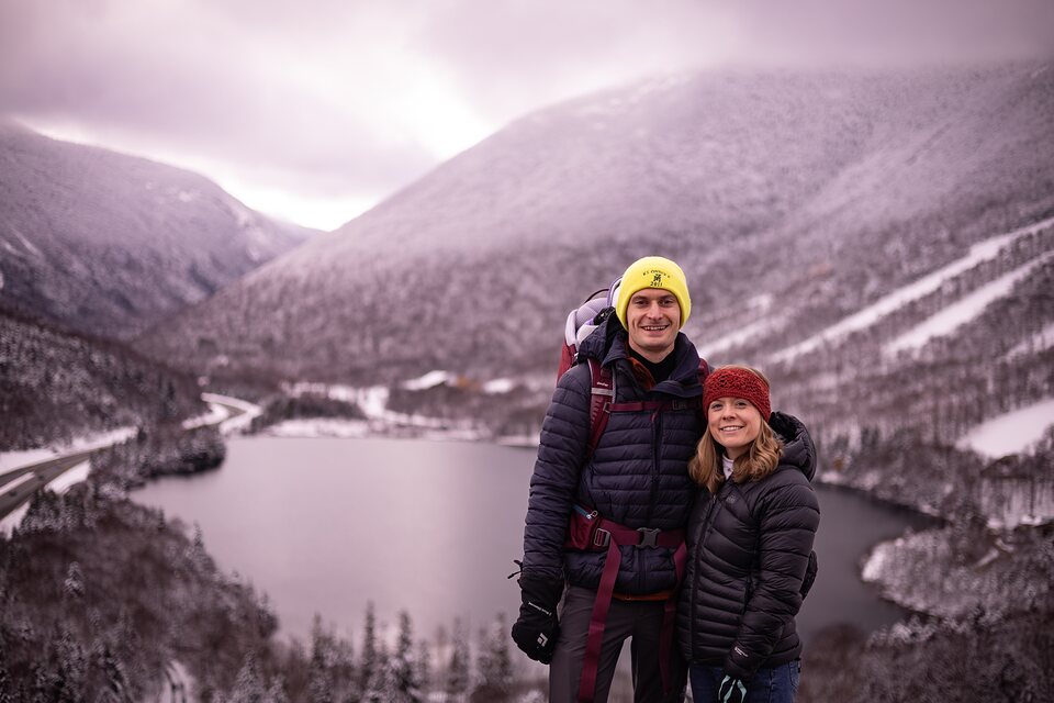 Couple on a snowy overlook above a frozen lake
